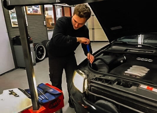 Jordie Berghorst aan het werk onder de motorkap van een auto